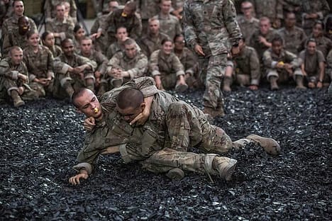 Soldaten üben den Bodenkampf, aber es könnte sowohl sportliches, als auch realitätsbasiertes Training sein.
